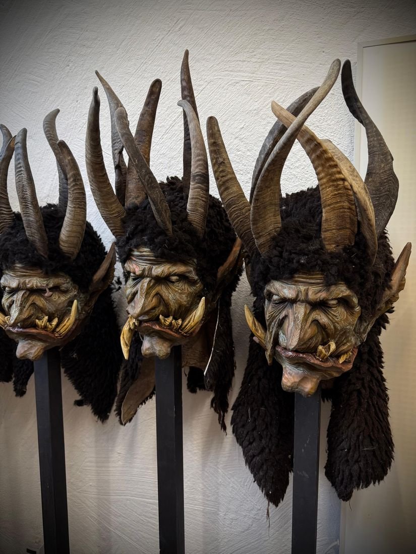 Reihe dunkler Krampusmasken mit Hauern